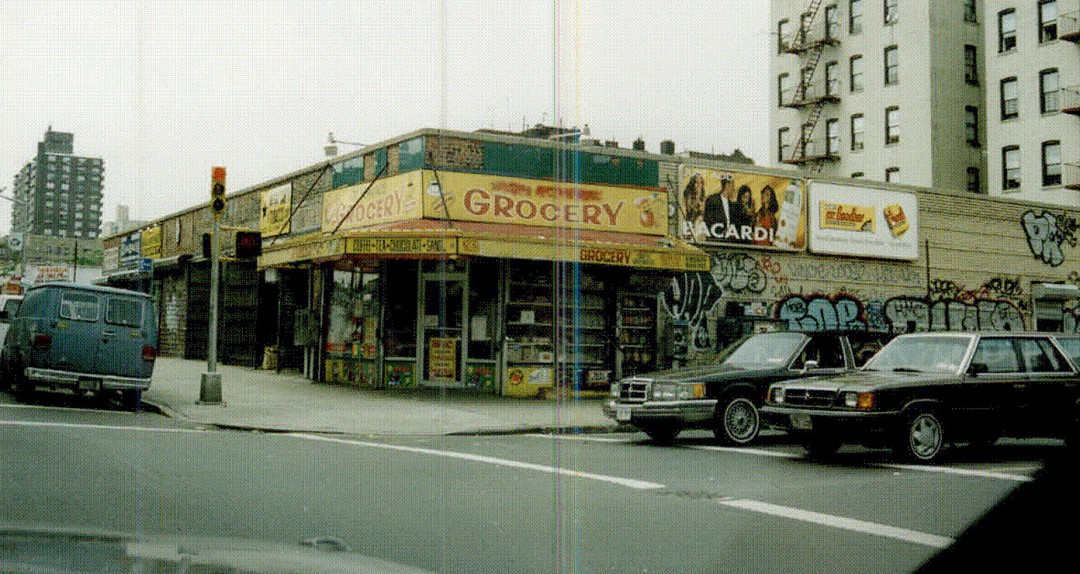 Historical view of corner store with yellow and green facade
